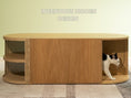 Load image into Gallery viewer,  (Light) An innovative hidden litter box design with a cat gracefully exiting, featuring circular side entrances and a sleek oak wood finish, blending seamlessly into home decor.
